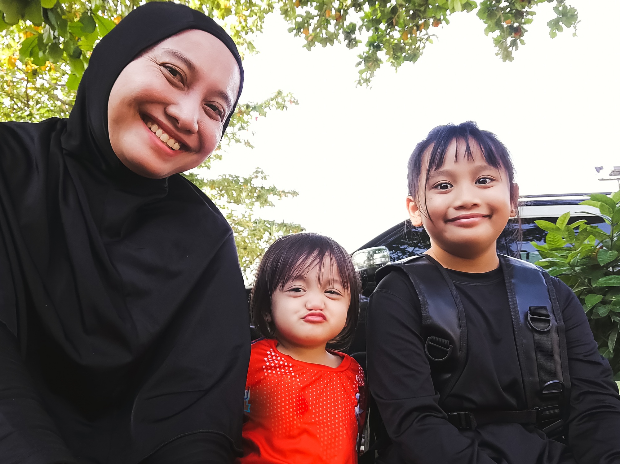 happy mother in hijab with daughters